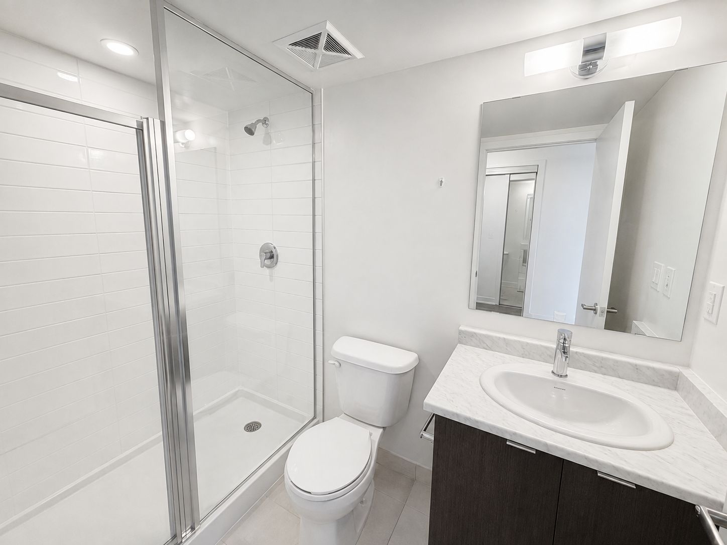 Modern bathroom with glass shower and marble vanity